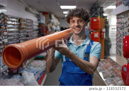 Waist portrait of smiling plumber carrying pipe for water supply or heating system Waist portrait of smiling plumber carrying pipe for water supply or heating system 118532572