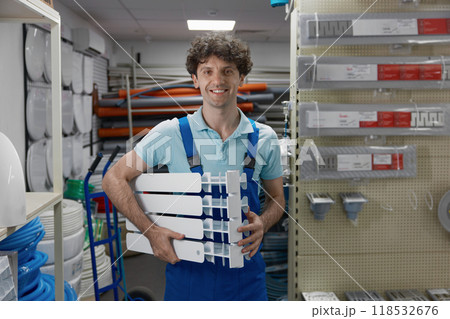 Portrait of happy smiling satisfied plumber holding section of radiator Portrait of happy smiling satisfied plumber holding section of radiator 118532676
