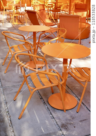 Coffee shop restaurant, orange furniture tables and chairs for guests. cozy street with cafe tables Coffee shop restaurant, orange furniture tables and chairs for guests. cozy street with cafe tables 118533828