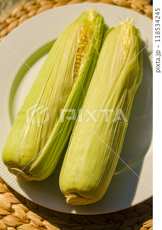 two fresh corn cobs on white plate . High quality photo 118534245