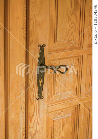 Old wooden door with a vintage black metal l door knob. . High quality photo 118534246