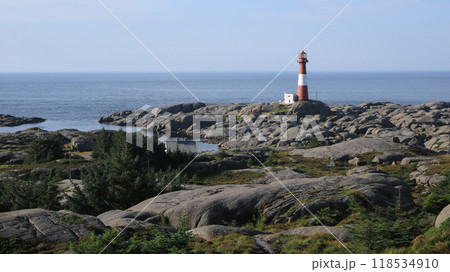 Cast iron Eigeroy lighthouse, rock formations and sea, Norway. 118534910