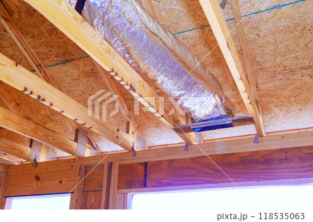 Construction process silver insulation ventilation HVAC pipes are installed on ceiling to roof 118535063