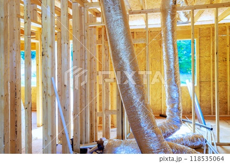 Installing silver insulation ventilation HVAC pipes on ceiling to roof of construction process 118535064