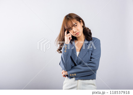 Portrait of an Asian business woman deep in thought thinking chin in her finger, pondering a question. Studio shot on white background with ample copy space, portraying her contemplative expression Portrait of an Asian business woman deep in thought thinking chin in her finger, pondering a question. Studio shot on white background with ample copy space, portraying her contemplative expression 118537918