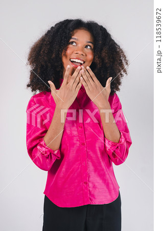 Surprised African American woman in pink shirt with hands on face. Isolated on white background. 118539672