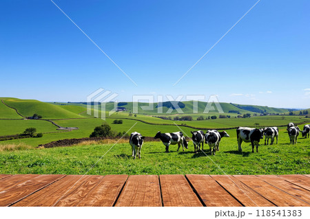 田園風景と牧草地で草を食む牛たちの風景、木製テーブルの前景 118541383