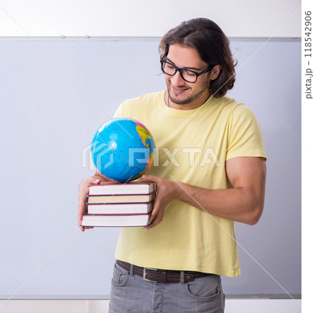 Young male geography teacher in front of whiteboard Young male geography teacher in front of whiteboard 118542906