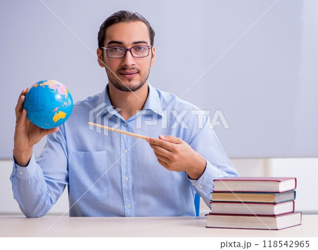 Young male geography teacher in front of whiteboard Young male geography teacher in front of whiteboard 118542965
