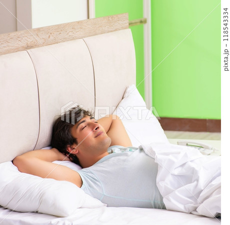 Young man having trouble waking up in early morning 118543334