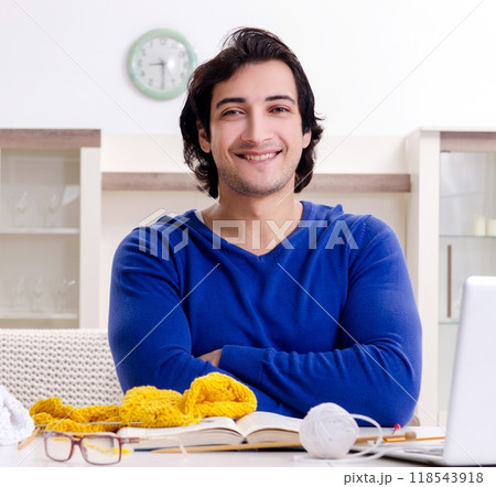 Young good looking man knitting at home 118543918
