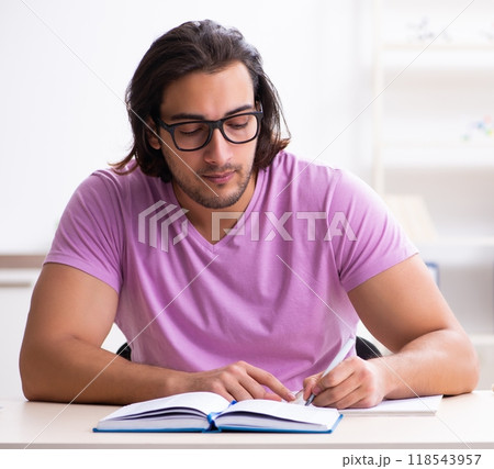 Young male student preparing for exams at classroom Young male student preparing for exams at classroom 118543957