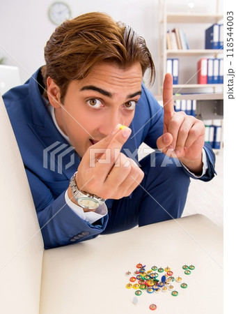 Office prank with sharp thumbtacks on chair 118544003