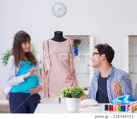 Pregnant woman visiting tailor for new clothing 118544313