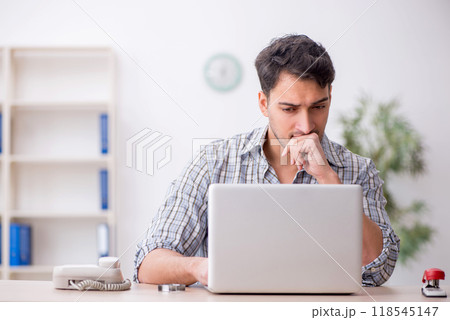 Young male employee working in the office Young male employee working in the office 118545147