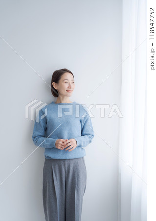 部屋の壁際に立つ女性 部屋の壁際に立つ女性 118547752