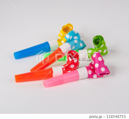 Rolled festive noisemaker or party whistle on the white 118548753