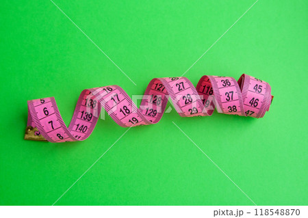 Pink centimeter measure tape on colorful background Pink centimeter measure tape on colorful background 118548870