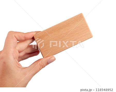 Wooden brick block in hand isolated on the white 118548952