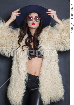 Stylish woman with red lips make-up and long wavy hair wearing blue hat Stylish woman with red lips make-up and long wavy hair wearing blue hat 118550634