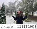 Cheerful little child girl laughing, walking and enjoying in the snow, outdoor winter portrait 118551004