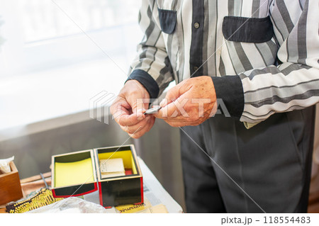 A man wearing a striped shirt is holding a piece of paper firmly 118554483