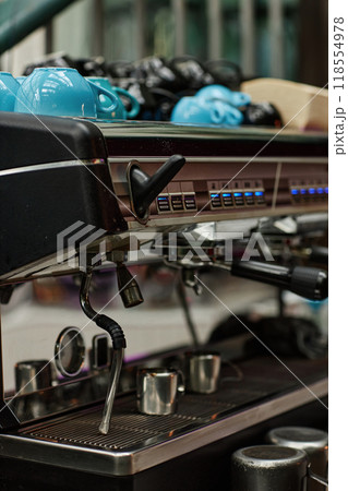 Vertical medium close up of black modern coffee machine with multicolored cups on its top Vertical medium close up of black modern coffee machine with multicolored cups on its top 118554978