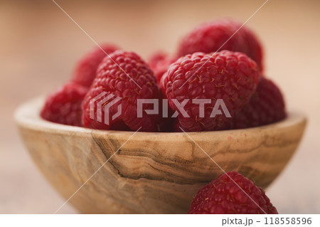 fresh raspberries in wood bowl on table 118558596