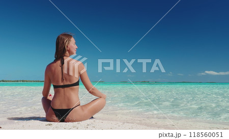 Beautiful woman relax on Bora Bora tropic sand beach. Crystal turquoise water, white sand, blue sky, sunny day. Caucasian female in bikini sit enjoy outdoor lifestyle travel on summer holiday vacation 118560051