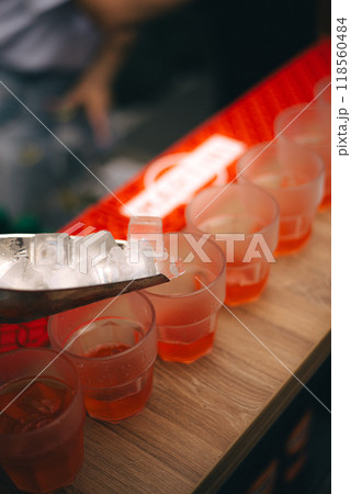 Ice cubes are poured into cocktails Ice cubes are poured into cocktails 118560484
