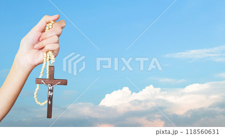Brown wooden cross holding in hand, symbolizing, recalling and spreading of Jesus Christs love to all Christians Brown wooden cross holding in hand, symbolizing, recalling and spreading of Jesus Christs love to all Christians 118560631