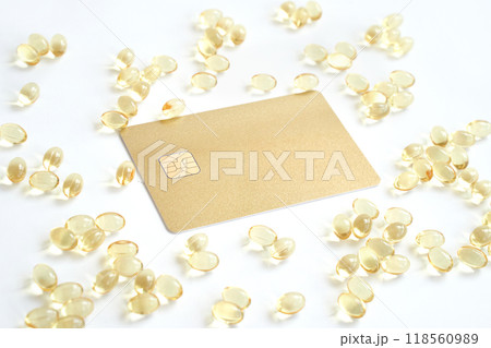 Golden card surrounded by transparent capsules on white background for health 118560989