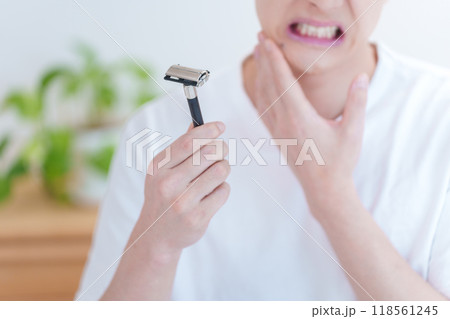 髭剃りで剃刀負けをする男性 118561245