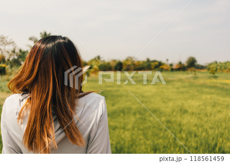 Woman resting at the rice fields after working out in the morning. Woman resting at the rice fields after working out in the morning. 118561459