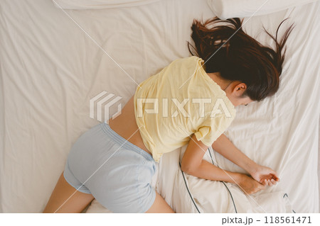 Above view of woman sleeping on white bed in very cozy pose. 118561471