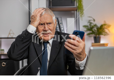 Senior businessman using smartphone browsing, loses becoming shocked sudden lottery results at home 118562396