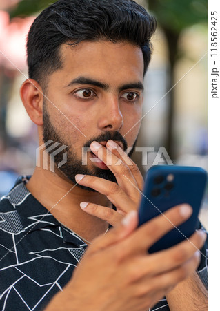 Unhappy sad Indian man use smartphone bad message news, fortune loss, game fail in city street park 118562425