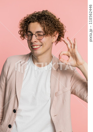 Happy young man showing ok gesture, like sign positive feedback, celebrate victory, approve idea Happy young man showing ok gesture, like sign positive feedback, celebrate victory, approve idea 118562446