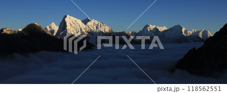 Bright lit peaks of Ama Dablam, Cholatse, Taboche and Tobuche. Sea of fog, autumn in the Gokyo Valley, Nepal. Bright lit peaks of Ama Dablam, Cholatse, Taboche and Tobuche. Sea of fog, autumn in the Gokyo Valley, Nepal. 118562551