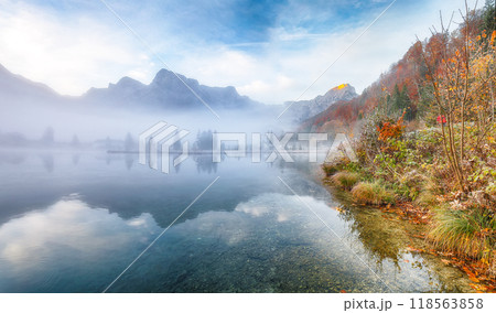 Captivating autumn scene of foggy and sunny morning on Almsee lake. 118563858