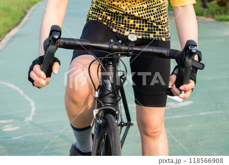 Cropped shot of cyclist hand wearing glove and holding a road bike brake. Brake is use to reduces the speed of a bicycle from moving. 118566908