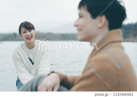 アウトドアで笑顔で会話する20代の男女 118566982
