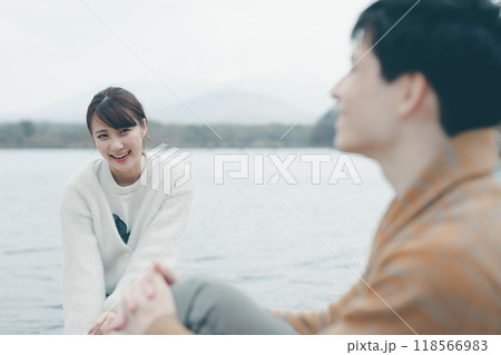 アウトドアで笑顔で会話する20代の男女 118566983