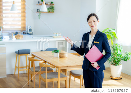 住宅展示場を案内する女性営業マン 住宅展示場を案内する女性営業マン 118567927