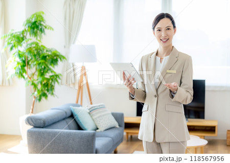 住宅展示場を案内する女性営業マン 118567956