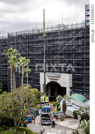 マンションの大規模修繕工事の工事現場で足場など仮設工事資材を高所に吊り上げるクレーン車 118568822