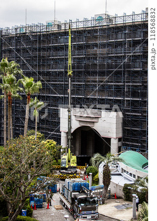 マンションの大規模修繕工事の工事現場で足場など仮設工事資材を高所に吊り上げるクレーン車 118568832