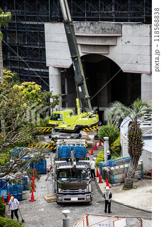 マンションの大規模修繕工事の工事現場で足場など仮設工事資材を高所に吊り上げるクレーン車 118568838