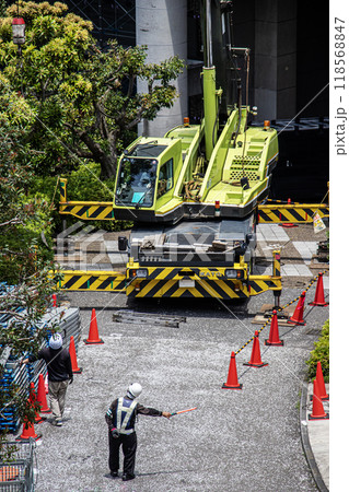 マンションの大規模修繕工事の工事現場で足場など仮設工事資材を高所に吊り上げるクレーン車 マンションの大規模修繕工事の工事現場で足場など仮設工事資材を高所に吊り上げるクレーン車 118568847