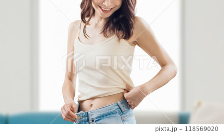 ダイエットに成功して喜ぶ笑顔の女性 118569020